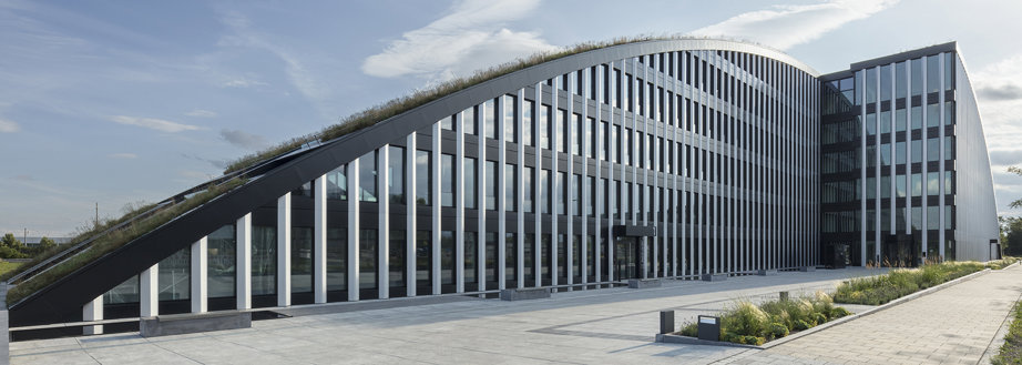 The Innovation Park – Innovationsbogen in German – was designed to serve as an inspiration through its arch-shaped architecture and integrated sustainability, including the first building façade ever made of 100 percent end-of-life aluminium.  Innovationsbogen is 145 meters long and has an area of 14,800 square meters. An elongated building with six floors at the highest point, it appears to rise out of the landscape, its grassy roof like a meadow.  Most innovative office building in the region with a pioneering façade  Again, Innovationsbogen is about sustainability. With its advanced energy concept, in which photovoltaic systems mounted on the roof cover the building’s electricity demand and where the air conditioning for the building is provided by special heating and cooling sails, the building was designed to achieve LEED Platinum certification. Another key component is the building’s unique façade.  My employer, the systems house Wicona, realized the façade with a special construction of its WICTEC EL evo element façade.  Aluminium is the best material for façades  Aluminium is the best material I know to use in façades, for several reasons. One, it combines good mechanical properties with the ease to obtain any shape of profile that would suit the specifications of the façade.  In addition, this mechanical performance, in a façade, means ensuring the façade’s ability to resist stress factors such as wind pressure and the weight of other components entering its composition, and its ability to accommodate possible movements of the structure, from small natural or structural movements to major displacements when buildings need to be earthquake-safe.  Near-zero aluminium for the façade elements  The façade elements we manufactured for Innovationsbogen have an integrated sun protection guide and a baffle plate as fall protection. As the material, we used Hydro CIRCAL 100R – a 6xxx-series alloy made of 100 percent end-of-life aluminium and with a footprint less than 0.5 kg CO2 per kg aluminium.  The façade used 85 tonnes of this near-zero aluminium, which, when compared with the European average of 6.7 kg CO2/kg aluminium, corresponds to a CO2 reduction of 527 tonnes.  Reducing the climate impact with post-consumer scrap aluminium  According to the United Nations Environment Program (UNEP), the building and construction industry is by far the largest emitter of greenhouse gases, accounting for 37 percent of global emissions. The beauty of Hydro CIRCAL 100R is that it provides architects and builders with completely new possibilities to reduce the climate impact of buildings.  By using 100 percent recycled post-consumer aluminium, they can make a step change and prove that achieving a zero-carbon footprint in buildings is possible.  That said, producing an aluminium product containing only used metal is a challenge because of the complex elements a product brings after it reaches end of life, such as paint, plastics and other contaminants.  Utilizing complex scrap types in a high-quality recycled product requires a recycling technology that includes sorting, shredding and melting technologies. Only when you can remove all foreign materials to ensure an aluminium fraction as close to 100 percent as possible, can you take the next step.  The science of chemistry is also part of the picture, because for a near-zero product, you need to manage the scrap chemistries against the alloy chemistry specification. At the 100 percent level, the chemistry is literally determined by scrap chemistry. You have no possibility to fine-tune with standard ingot.  We achieved this for Innovationsbogen, a building that is really something special.