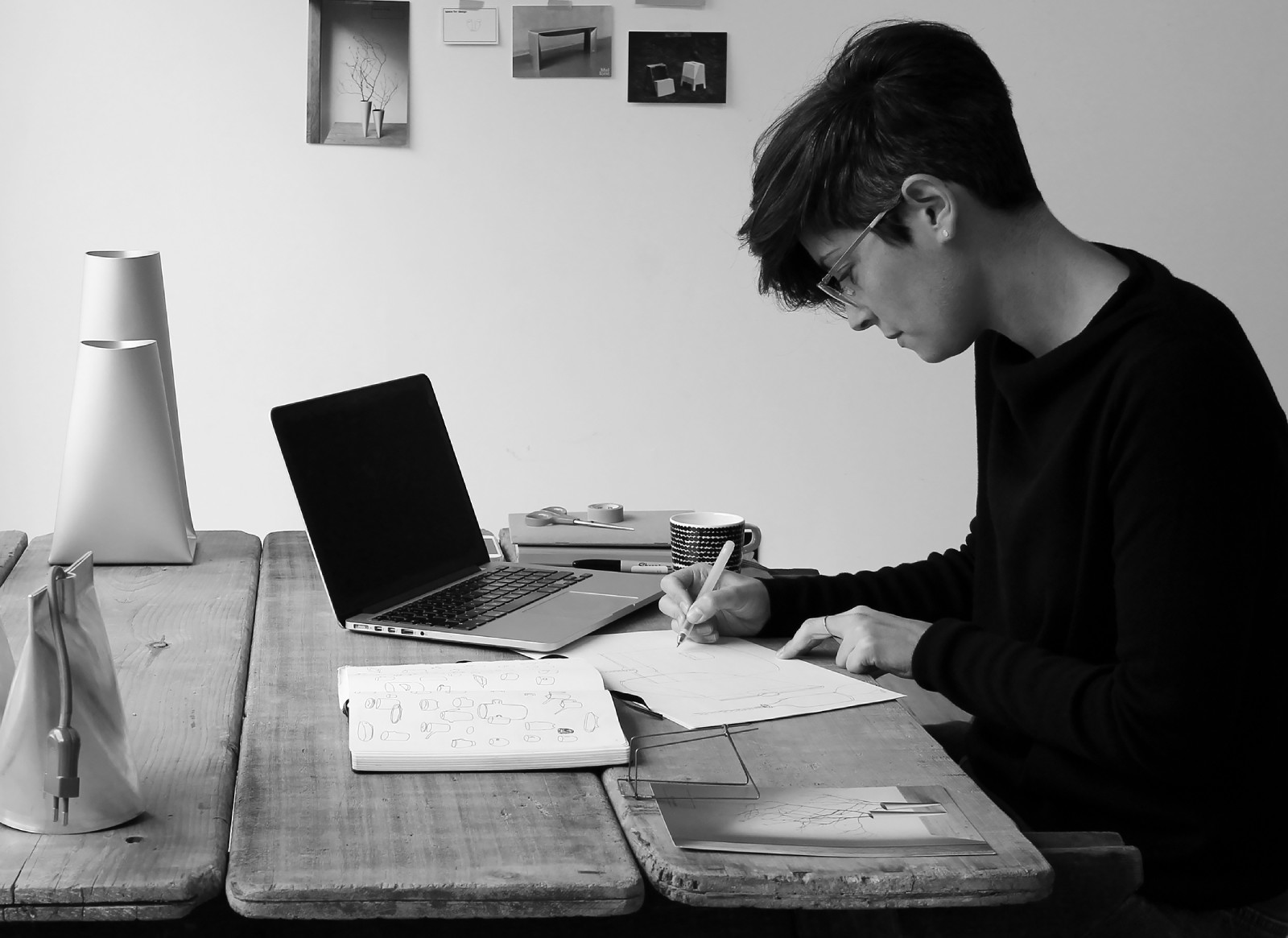 a man sitting at a table with a laptop and papers